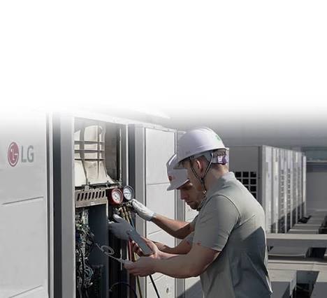 Technician checking gauges on a rooftop HVAC condensing unit