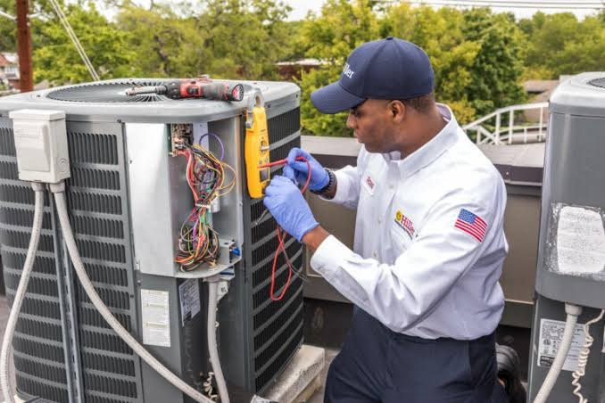 HVAC service technician inspecting a residential cooling system in Kokomo Indiana