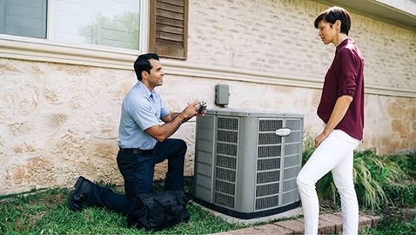 HVAC technician discussing an outdoor air conditioning system with a homeowner